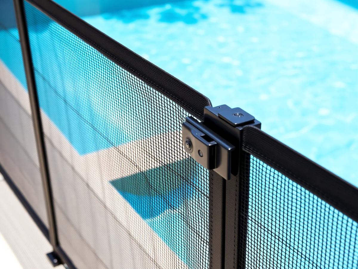 Black mesh pool fence with a self-latching safety gate